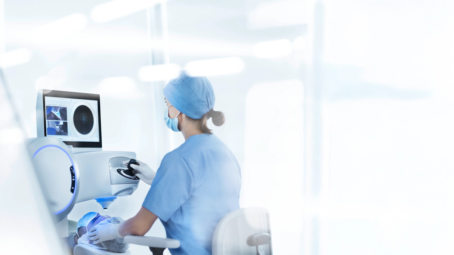 Auf dem Bild ist eine Person zu sehen, die in einer medizinischen oder chirurgischen Umgebung arbeitet. Die Person, die offenbar eine Krankenschwester oder medizinische Fachkraft ist, sitzt an einem Schreibtisch und bedient einen Computer. Auf dem Bildschirm des Computers scheint eine MRT-Aufnahme zu sehen zu sein, was darauf hindeutet, dass diagnostische oder medizinische Bildgebungsaufgaben durchgeführt werden. Die Person trägt einen Kittel, eine OP-Haube mit blauem Streifen und Schutzhandschuhe, was in diesem Zusammenhang die Standardkleidung für medizinisches Fachpersonal ist. Es sind keine Texte oder markanten Marken zu sehen, die konkrete Informationen über den Ort oder die Identität der abgebildeten Person liefern.
